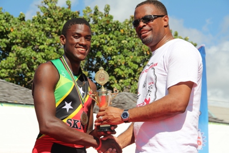 Deputy Premier of Nevis and Minister of Youth and Sports on Nevis Hon. Mark Brantley presents trophy to young Charlestown triathlete Romel Gaskin, after he arrived 4th at the finish line. He was the first Nevisian to finish the MaccaX Nevis International Triathlon on November 16, 2013